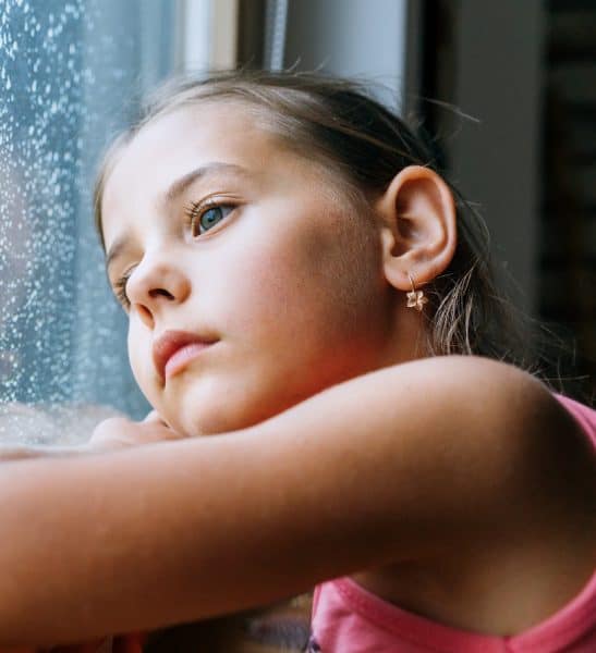 Young Girl looking out rainy window