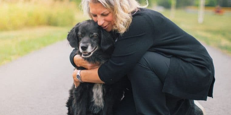Woman hugging a dog in comfort
