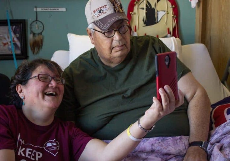 Indigenous man and volunteer Facetiming with family