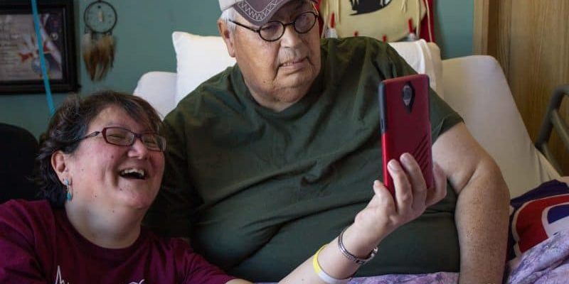 Indigenous man and volunteer Facetiming with family